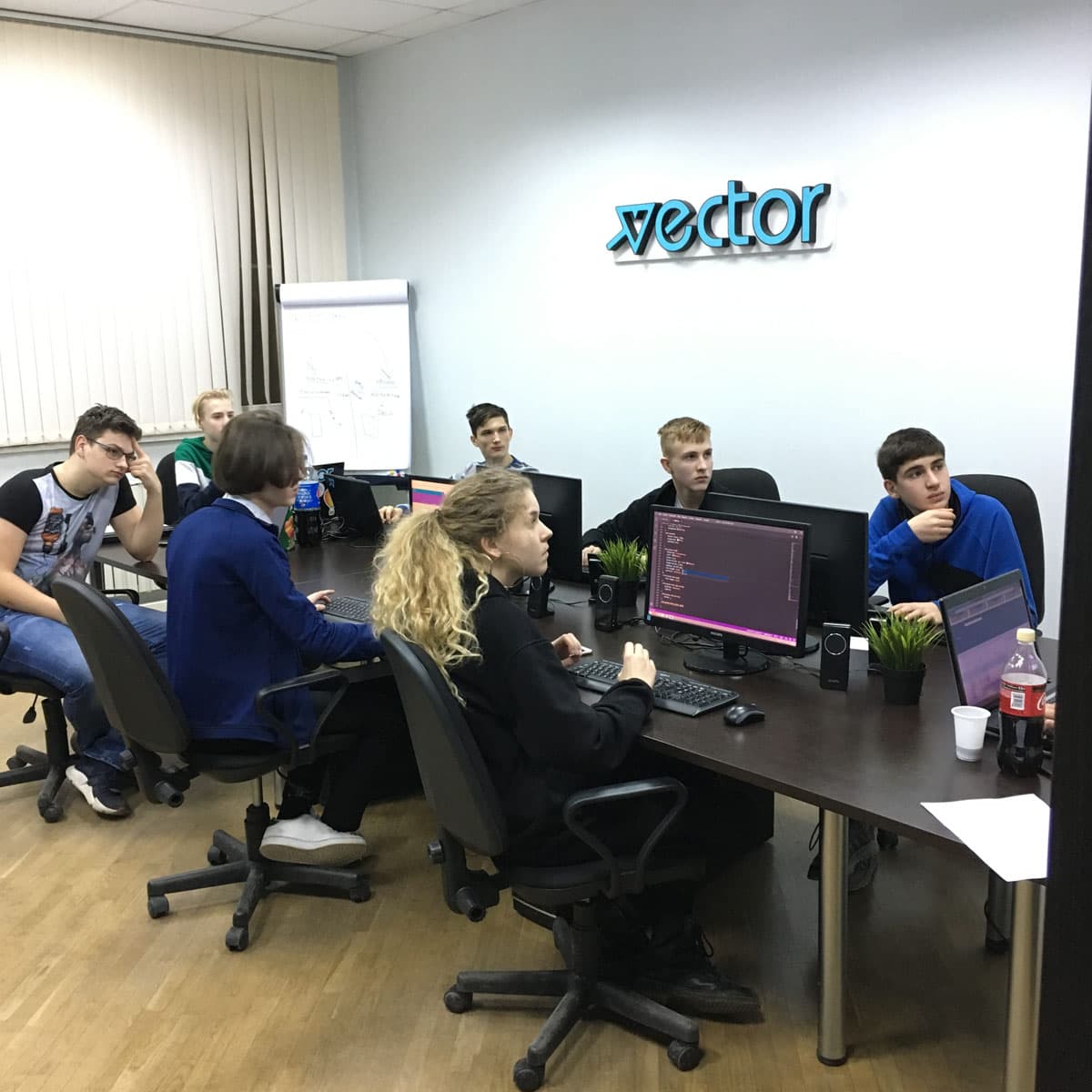 Подростки разбирают код вместе с преподавателем