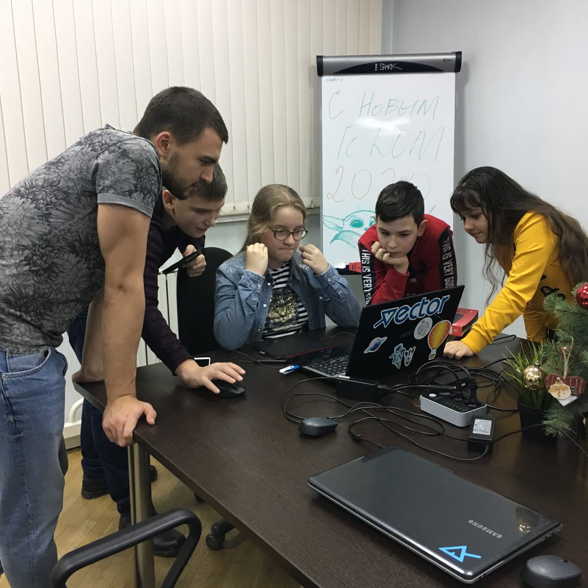 Команда учеников решает задачу за ноутбуком