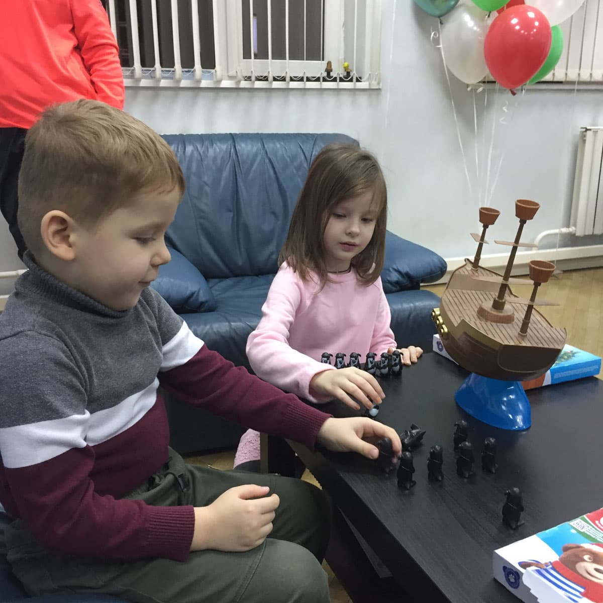Младшие ученики играют в настольную игру на занятии