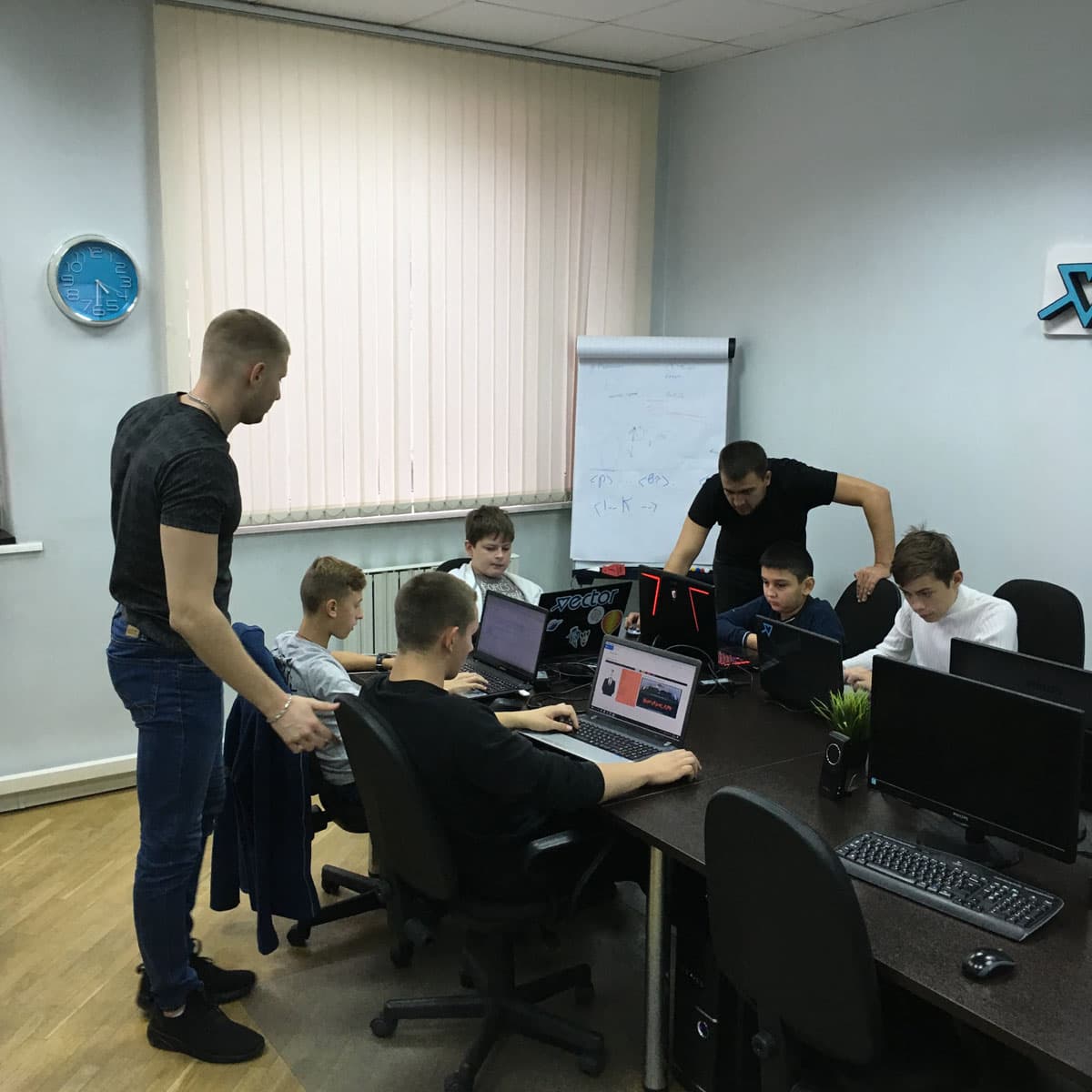 Два преподавателя помогают ученикам во время занятия